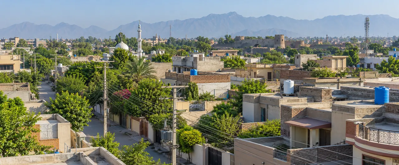 AI-generated illustrative residential scene inspired by Peshawar, with rooftops and electricity infrastructure